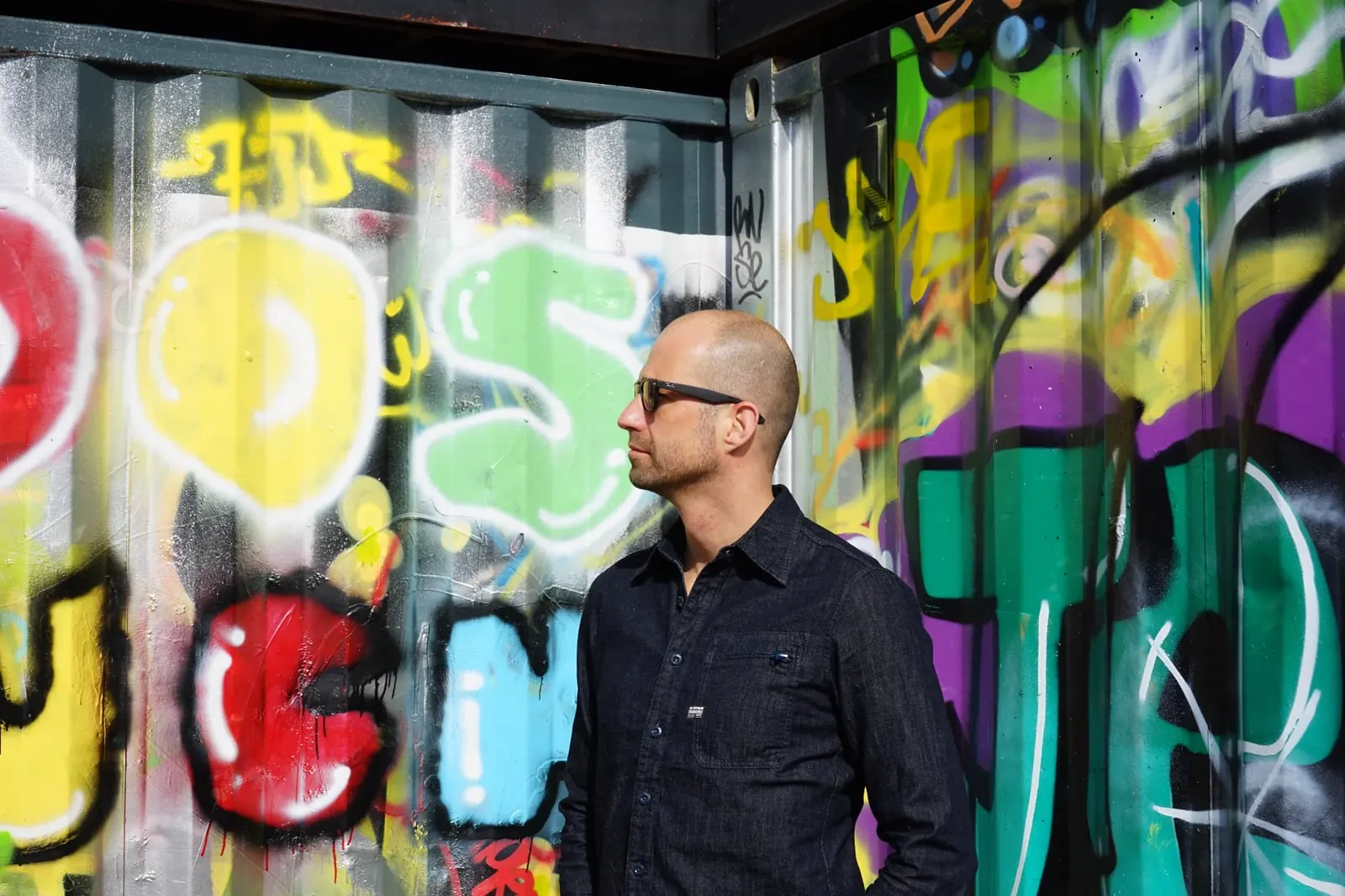 Johnny van Dyck in sunglasses beside a painted container