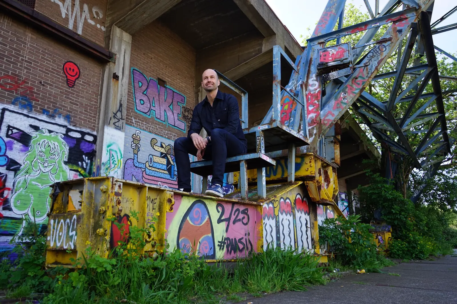Johnny van Dyck sitting on an old crane at an industrial site